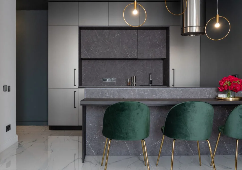 Cocina con frentes oscuros, barra y taburetes