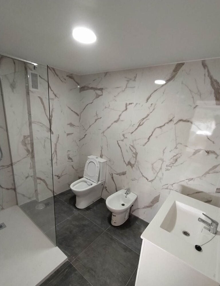 Baño reformado con revestimiento tipo mármol