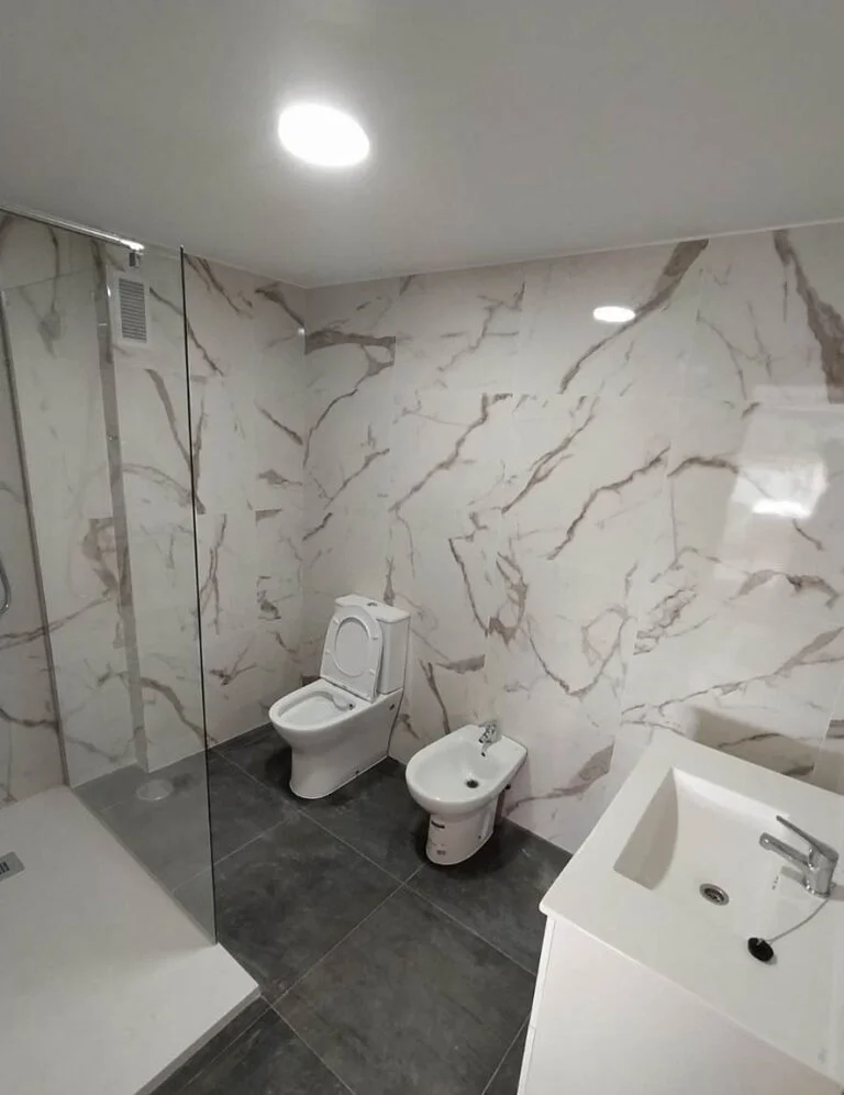 Baño reformado con revestimiento tipo mármol