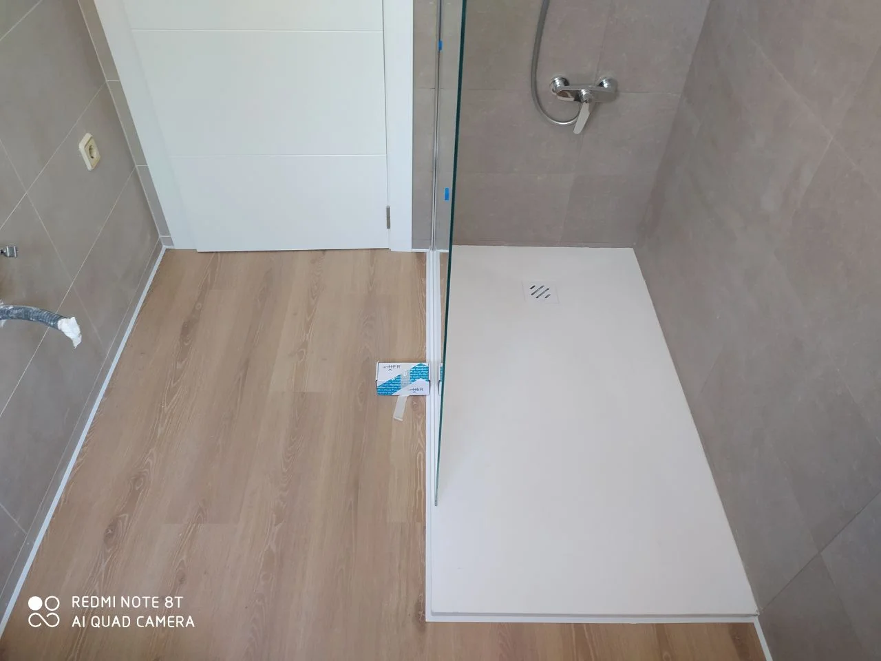Plato de ducha instalado junto a suelo laminado en una reforma en Valencia