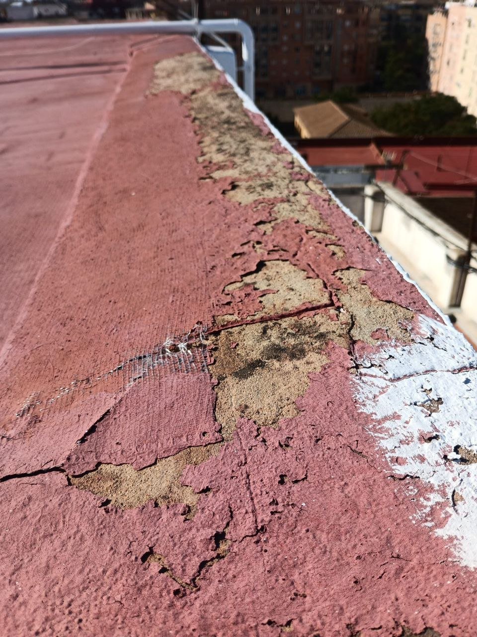 Detalle de impermeabilización deteriorada con la tela asfáltica agrietada en el encuentro con el peto