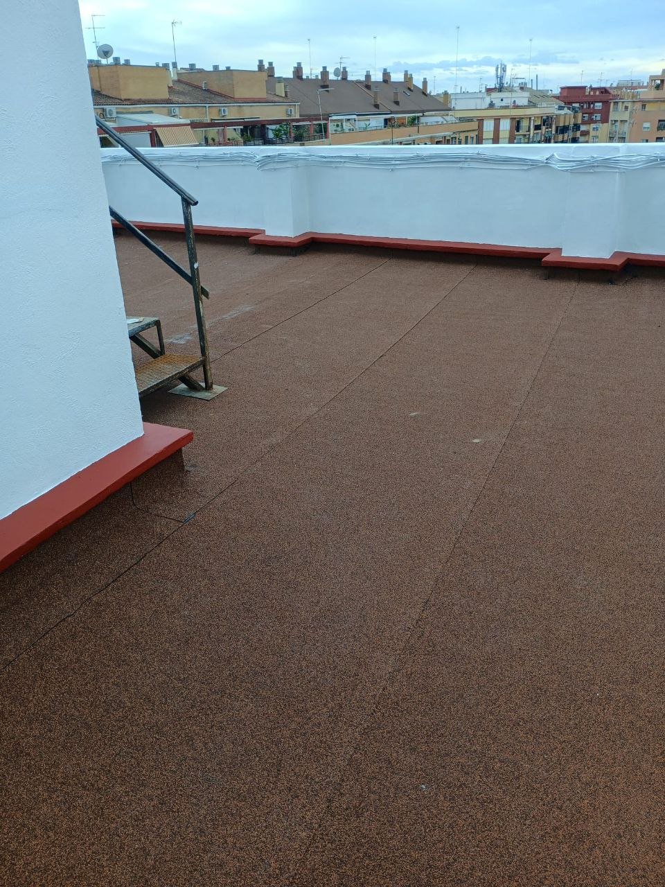 Terraza reformada con acceso por escalera y barandilla metálica