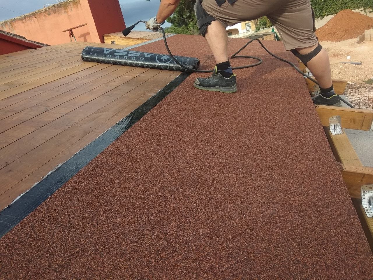 Operario aplicando el sellado con soplete durante la impermeabilización de la cubierta