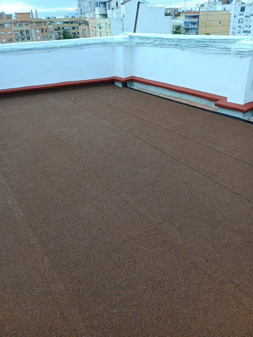 Encuentro entre pavimento y peto de terraza rematado con zócalo tras la impermeabilización