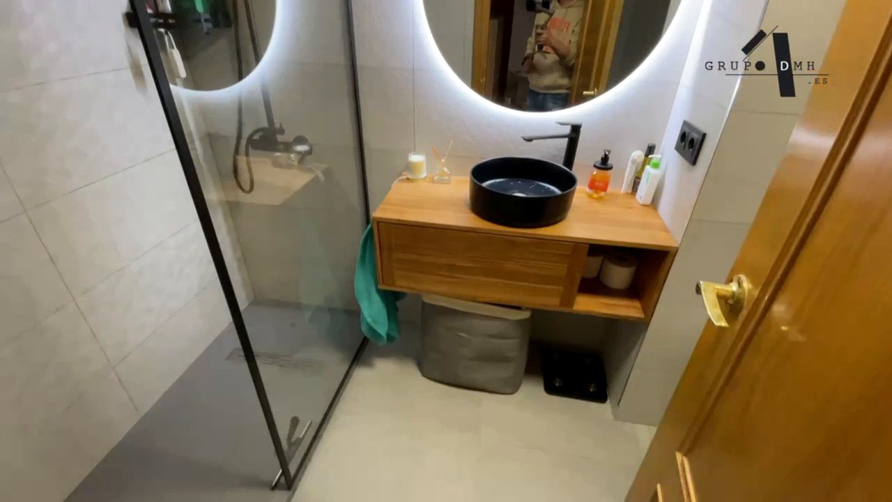 Ducha de obra y mueble de madera en un baño de Valencia
