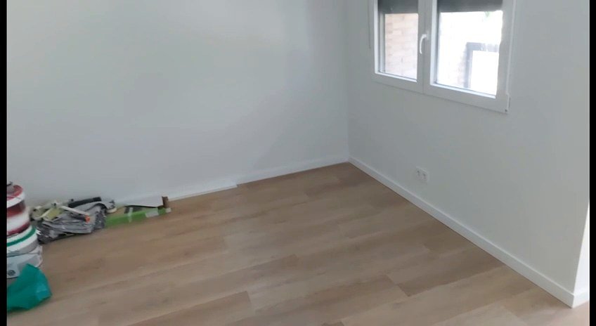 Habitación con suelo laminado tras la reforma en Valencia