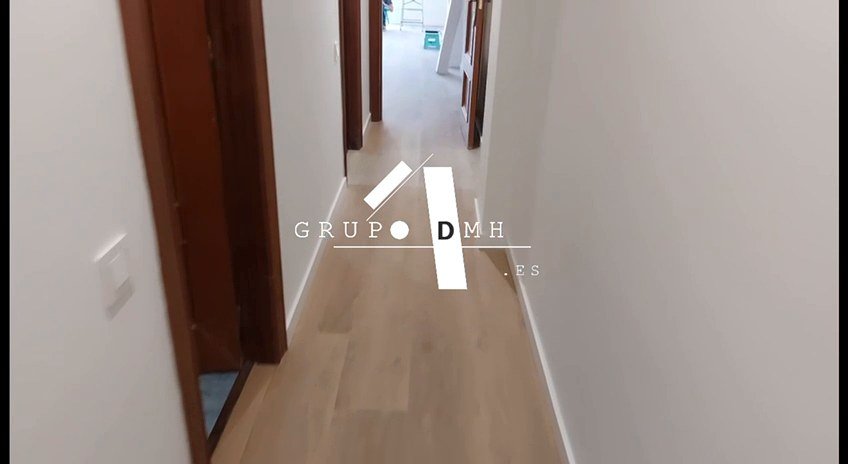 Pasillo con suelo laminado tras la reforma en Valencia