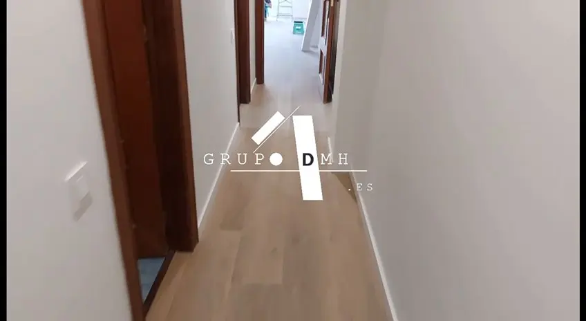 Pasillo con suelo laminado tras la reforma en Valencia